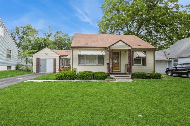 4234 E 68th St, Kansas City, MO 64132 - view of front of house with a front lawn, a chimney, and driveway