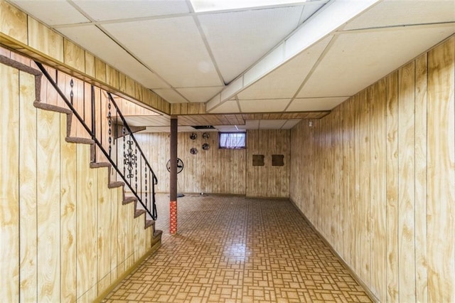 4234 E 68th St, Kansas City, MO 64132 - finished basement with a paneled ceiling, wood walls, and stairway