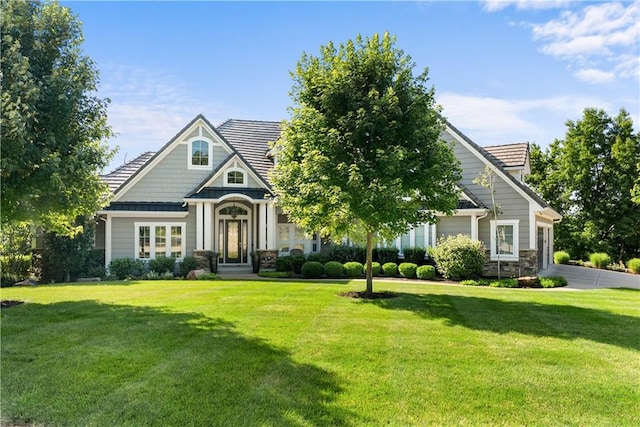4915 NW Canyon Ct, Lees Summit, MO 64064 - view of front of property featuring stone siding, a front yard, a garage, and driveway