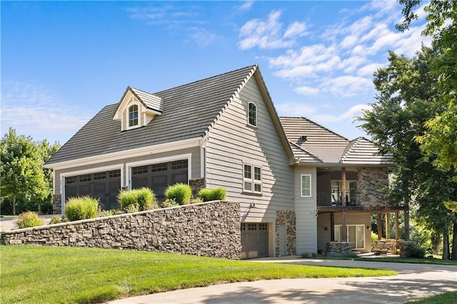 4915 NW Canyon Ct, Lees Summit, MO 64064 - view of home's exterior with a balcony, stone siding, a yard, and an attached garage