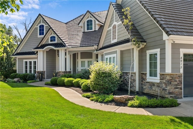 4915 NW Canyon Ct, Lees Summit, MO 64064 - craftsman-style home with a front yard, stone siding, and an attached garage