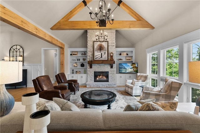 4915 NW Canyon Ct, Lees Summit, MO 64064 - living area featuring a chandelier, wood finished floors, a stone fireplace, built in shelves, and wainscoting