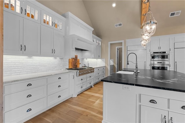 4915 NW Canyon Ct, Lees Summit, MO 64064 - kitchen featuring appliances with stainless steel finishes, decorative backsplash, white cabinetry, glass insert cabinets, and recessed lighting