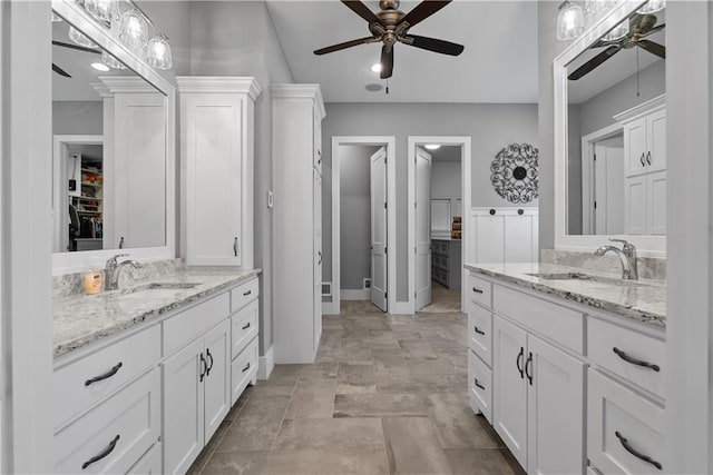 4915 NW Canyon Ct, Lees Summit, MO 64064 - bathroom with a ceiling fan, two vanities, a walk in closet, and stone finish flooring