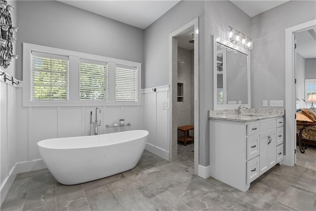 4915 NW Canyon Ct, Lees Summit, MO 64064 - full bathroom featuring a freestanding tub, vanity, tiled shower, wainscoting, and connected bathroom