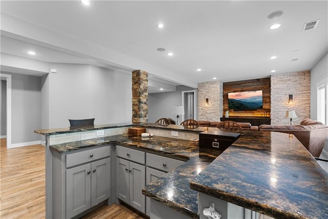 4915 NW Canyon Ct, Lees Summit, MO 64064 - kitchen with gray cabinetry, open floor plan, light wood-type flooring, dark stone counters, and recessed lighting