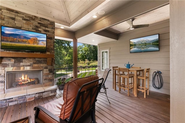 4915 NW Canyon Ct, Lees Summit, MO 64064 - wooden deck featuring an outdoor stone fireplace and outdoor dining area
