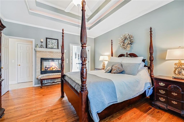 1617 Summit Valley Ln, Lees Summit, MO 64081 - bedroom featuring ornamental molding, wood finished floors, a raised ceiling, and a brick fireplace