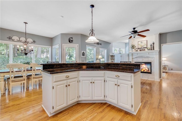 1617 Summit Valley Ln, Lees Summit, MO 64081 - kitchen featuring a fireplace, light wood finished floors, a ceiling fan, and white cabinets