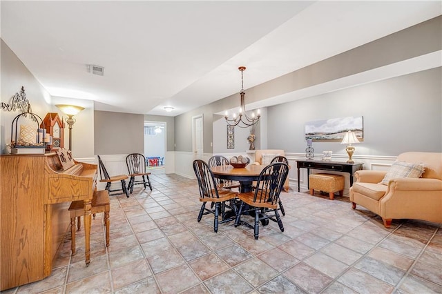 1617 Summit Valley Ln, Lees Summit, MO 64081 - dining space featuring a chandelier, wainscoting, and stone finish flooring