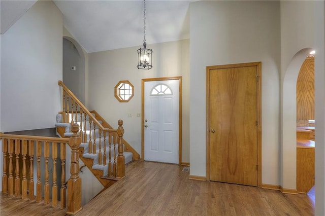 1733 NE Ridgeview Dr, Lees Summit, MO 64086 - entryway featuring arched walkways, wood finished floors, stairs, a chandelier, and a high ceiling