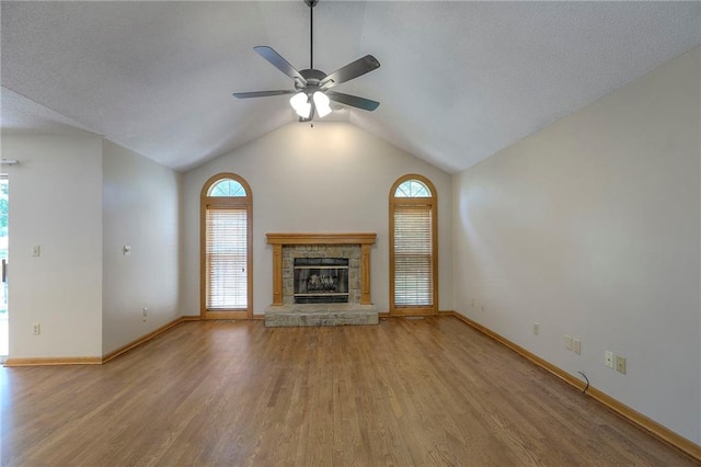 1733 NE Ridgeview Dr, Lees Summit, MO 64086 - unfurnished living room featuring wood finished floors, healthy amount of natural light, ceiling fan, a fireplace, and lofted ceiling