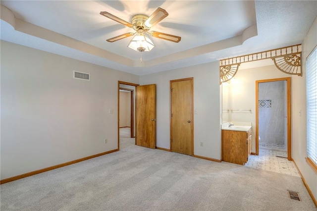 1733 NE Ridgeview Dr, Lees Summit, MO 64086 - unfurnished bedroom with light colored carpet, a tray ceiling, and a ceiling fan
