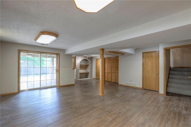 1733 NE Ridgeview Dr, Lees Summit, MO 64086 - unfurnished living room featuring wood finished floors, stairs, a textured ceiling, and a fireplace