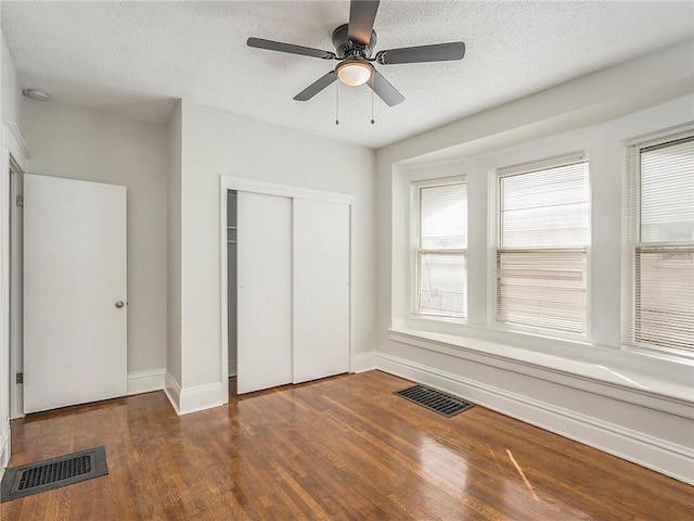 330 Wabash Ave, Kansas City, MO 64124 - unfurnished bedroom featuring wood finished floors, a closet, a textured ceiling, and a ceiling fan