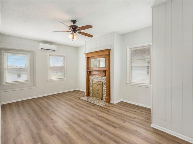330 Wabash Ave, Kansas City, MO 64124 - unfurnished living room with a wall mounted AC, wood finished floors, ceiling fan, a textured ceiling, and a fireplace