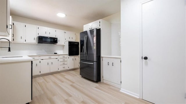 11400 E 62nd Ter, Raytown, MO 64133 - kitchen with black appliances, light wood finished floors, white cabinets, light countertops, and recessed lighting