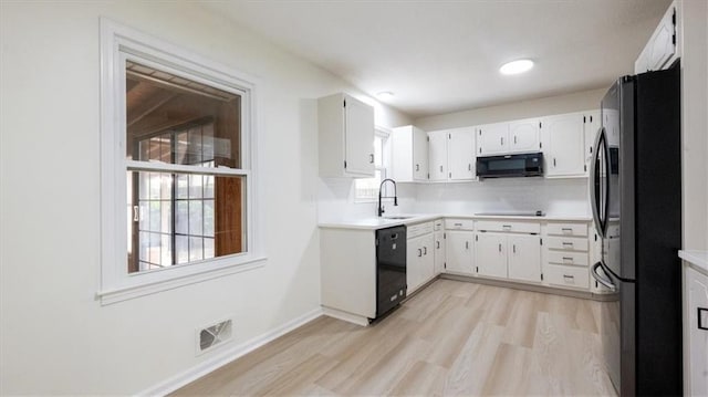 11400 E 62nd Ter, Raytown, MO 64133 - kitchen with black appliances, light wood-style floors, light countertops, and white cabinets