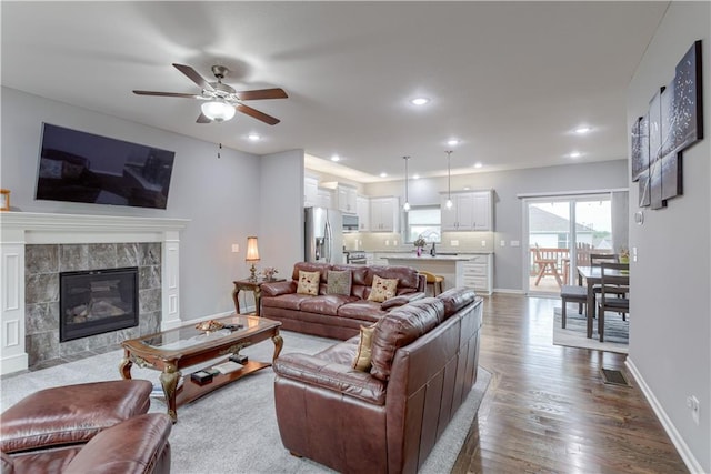 8604 NE 103rd St, Kansas City, MO 64157 - living area with a ceiling fan, dark wood-style flooring, recessed lighting, and a tiled fireplace