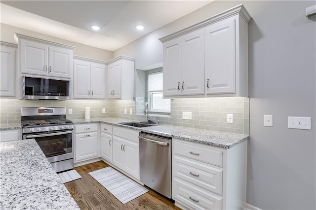 8604 NE 103rd St, Kansas City, MO 64157 - kitchen with stainless steel appliances, dark wood-style flooring, white cabinets, tasteful backsplash, and recessed lighting