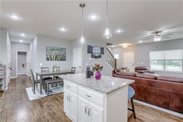 8604 NE 103rd St, Kansas City, MO 64157 - kitchen featuring wood finished floors, a center island, white cabinetry, recessed lighting, and pendant lighting