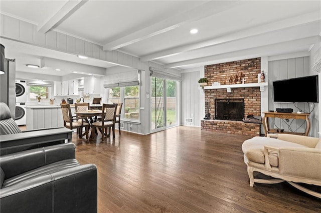 101 W 116th St, Kansas City, MO 64114 - living area with stacked washer / dryer, beam ceiling, dark wood-type flooring, healthy amount of natural light, and a fireplace