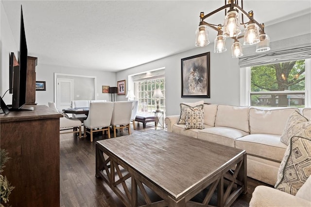 101 W 116th St, Kansas City, MO 64114 - living room featuring healthy amount of natural light, dark wood-style floors, and a chandelier
