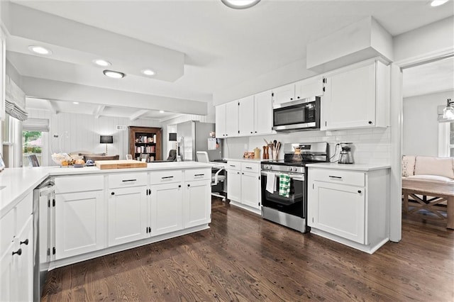 101 W 116th St, Kansas City, MO 64114 - kitchen with appliances with stainless steel finishes, dark wood-style flooring, white cabinets, a peninsula, and recessed lighting
