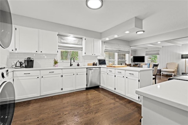 101 W 116th St, Kansas City, MO 64114 - kitchen featuring stainless steel dishwasher, a peninsula, stacked washer and clothes dryer, open floor plan, and dark wood finished floors