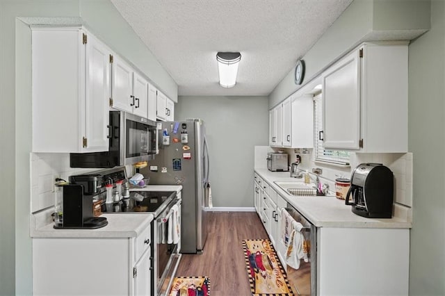 406 Crescent St, Lees Summit, MO 64063 - kitchen with stainless steel appliances, light countertops, wood finished floors, white cabinets, and a textured ceiling