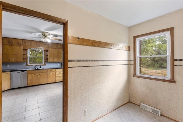 35365 Block Rd, Paola, KS 66071 - kitchen with stainless steel dishwasher, healthy amount of natural light, ceiling fan, and brown cabinetry