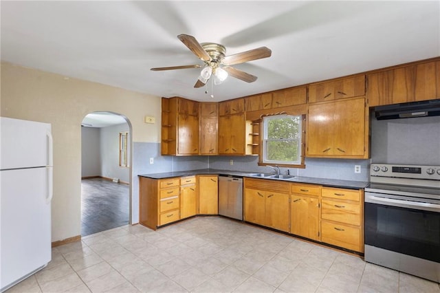 35365 Block Rd, Paola, KS 66071 - kitchen with appliances with stainless steel finishes, arched walkways, dark countertops, under cabinet range hood, and a ceiling fan