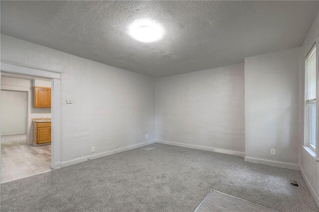 336 N 16th St, Kansas City, KS 66102 - spare room featuring a textured ceiling and light carpet
