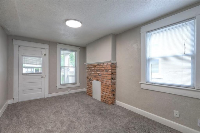 336 N 16th St, Kansas City, KS 66102 - unfurnished living room with a textured ceiling, carpet flooring, and a textured wall
