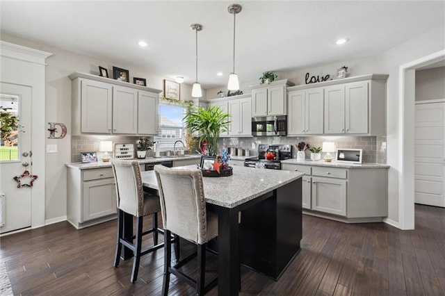 24631 W 126th St, Olathe, KS 66061 - kitchen with stainless steel appliances, dark wood-style floors, decorative backsplash, a center island, and decorative light fixtures