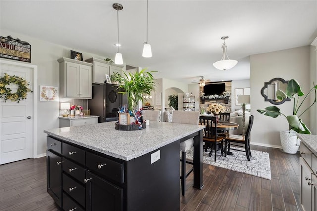 24631 W 126th St, Olathe, KS 66061 - kitchen with freestanding refrigerator, ceiling fan, a kitchen breakfast bar, dark cabinets, and a kitchen island