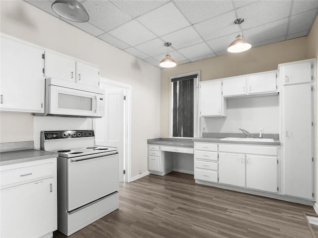 2703 Olive St, Saint Joseph, MO 64507 - kitchen with white appliances, white cabinetry, a drop ceiling, dark wood-style floors, and pendant lighting