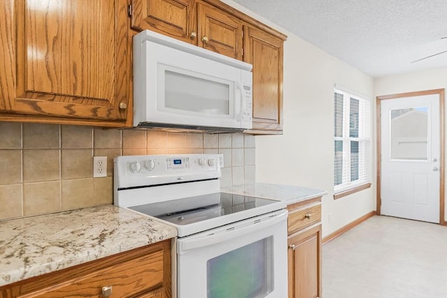 321 W Mockingbird St, Gardner, KS 66030 - kitchen featuring white appliances, brown cabinets, decorative backsplash, light stone counters, and a textured ceiling