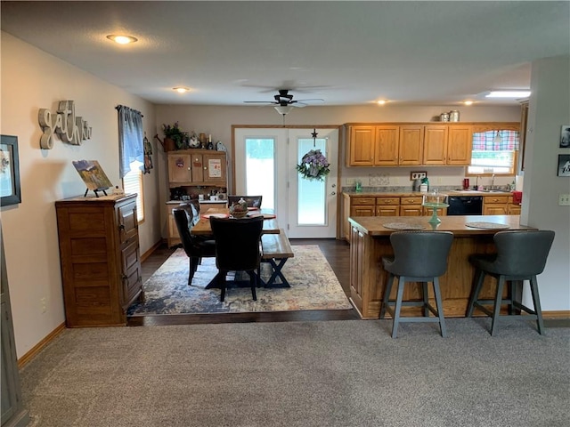 517 Brooklyn Ct, Frontenac, KS 66763 - kitchen with a breakfast bar, black dishwasher, a ceiling fan, and dark carpet