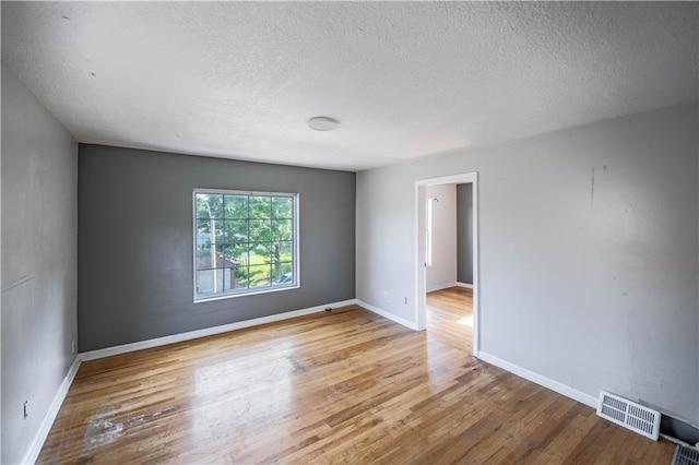 3620 Smart Ave, Kansas City, MO 64124 - spare room featuring a textured ceiling and wood finished floors