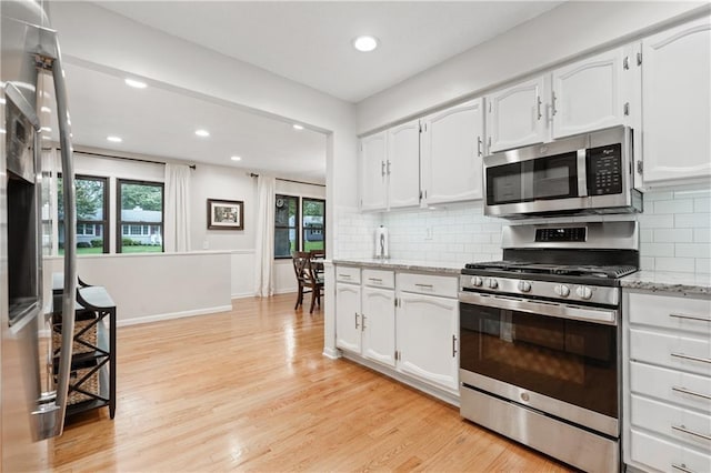 8039 Kessler St, Overland Park, KS 66204 - kitchen with stainless steel appliances, white cabinetry, light wood-style floors, recessed lighting, and decorative backsplash