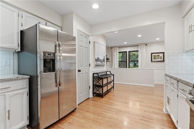 8039 Kessler St, Overland Park, KS 66204 - kitchen with stainless steel fridge, white cabinetry, decorative backsplash, light wood finished floors, and light stone countertops