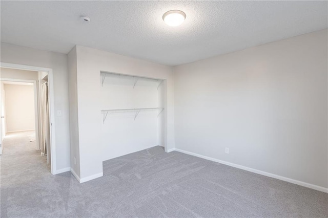 911 SE Hampton Ct, Lees Summit, MO 64063 - unfurnished bedroom featuring carpet floors, a textured ceiling, and a closet