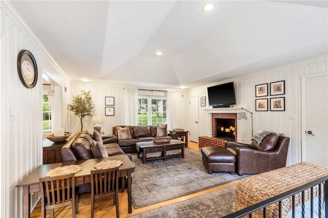 8315 Sagamore Rd, Leawood, KS 66206 - living room featuring wood finished floors, a fireplace, lofted ceiling, a decorative wall, and ornamental molding
