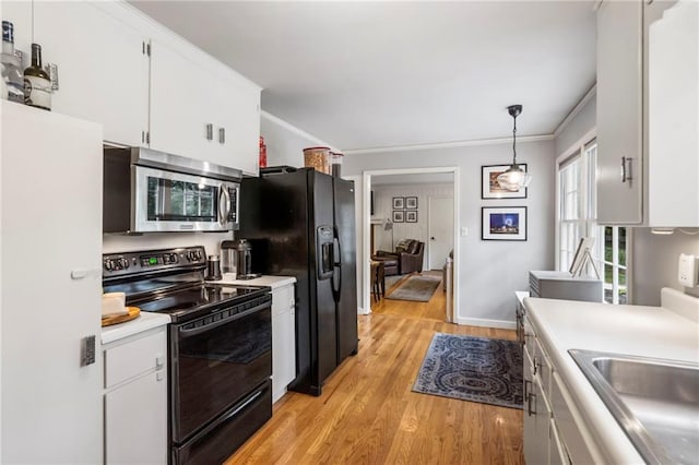 8315 Sagamore Rd, Leawood, KS 66206 - kitchen with black appliances, light countertops, crown molding, light wood finished floors, and white cabinets