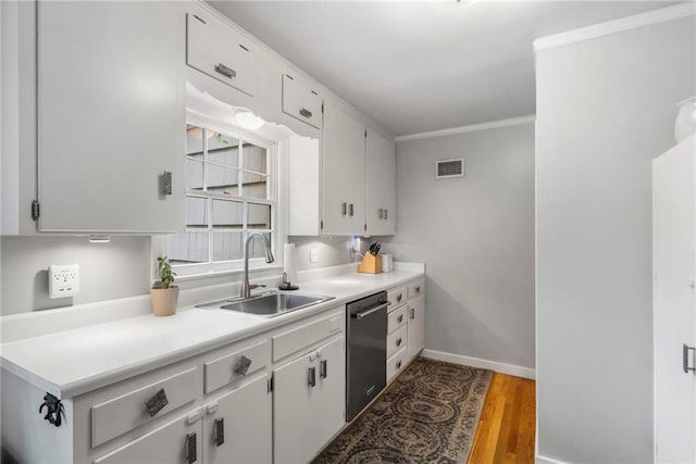 8315 Sagamore Rd, Leawood, KS 66206 - kitchen with stainless steel dishwasher, light countertops, ornamental molding, wood finished floors, and white cabinets