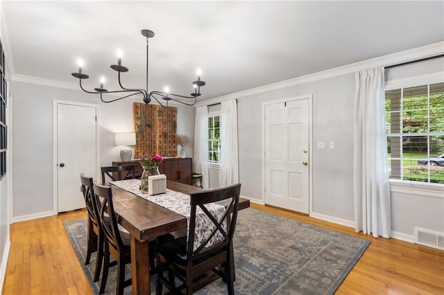 8315 Sagamore Rd, Leawood, KS 66206 - dining area with a chandelier, crown molding, and light wood-style floors