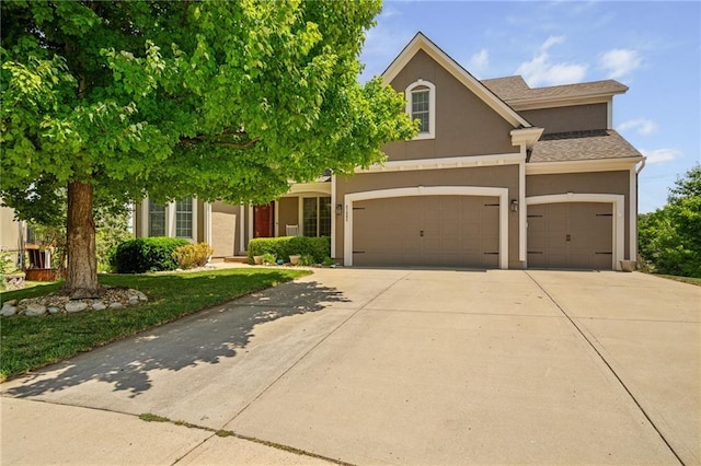 21502 W 98th Ter, Lenexa, KS 66220 - view of front of house featuring concrete driveway, stucco siding, and an attached garage