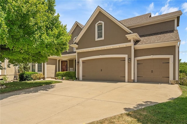 21502 W 98th Ter, Lenexa, KS 66220 - view of front of home with stucco siding, driveway, an attached garage, and a shingled roof