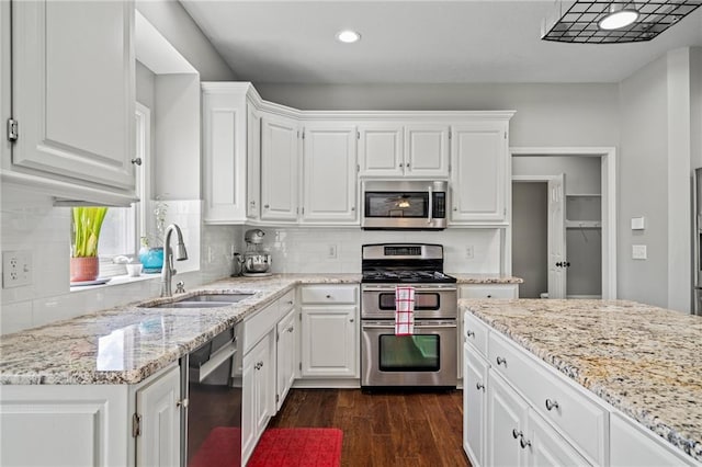 21502 W 98th Ter, Lenexa, KS 66220 - kitchen with stainless steel appliances, dark wood finished floors, white cabinetry, light stone counters, and backsplash